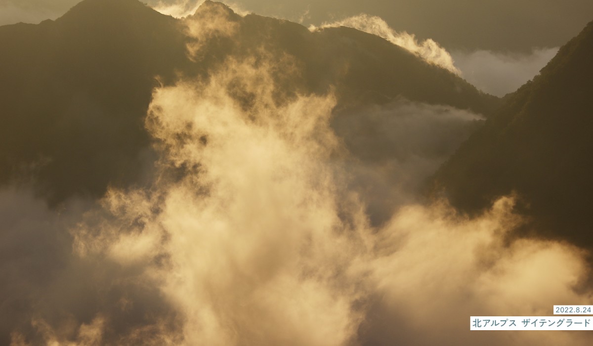 写真：2022.8.24 北アルプス ザイテングラード 山間に滞留する雲が朝日で黄金色に変わる