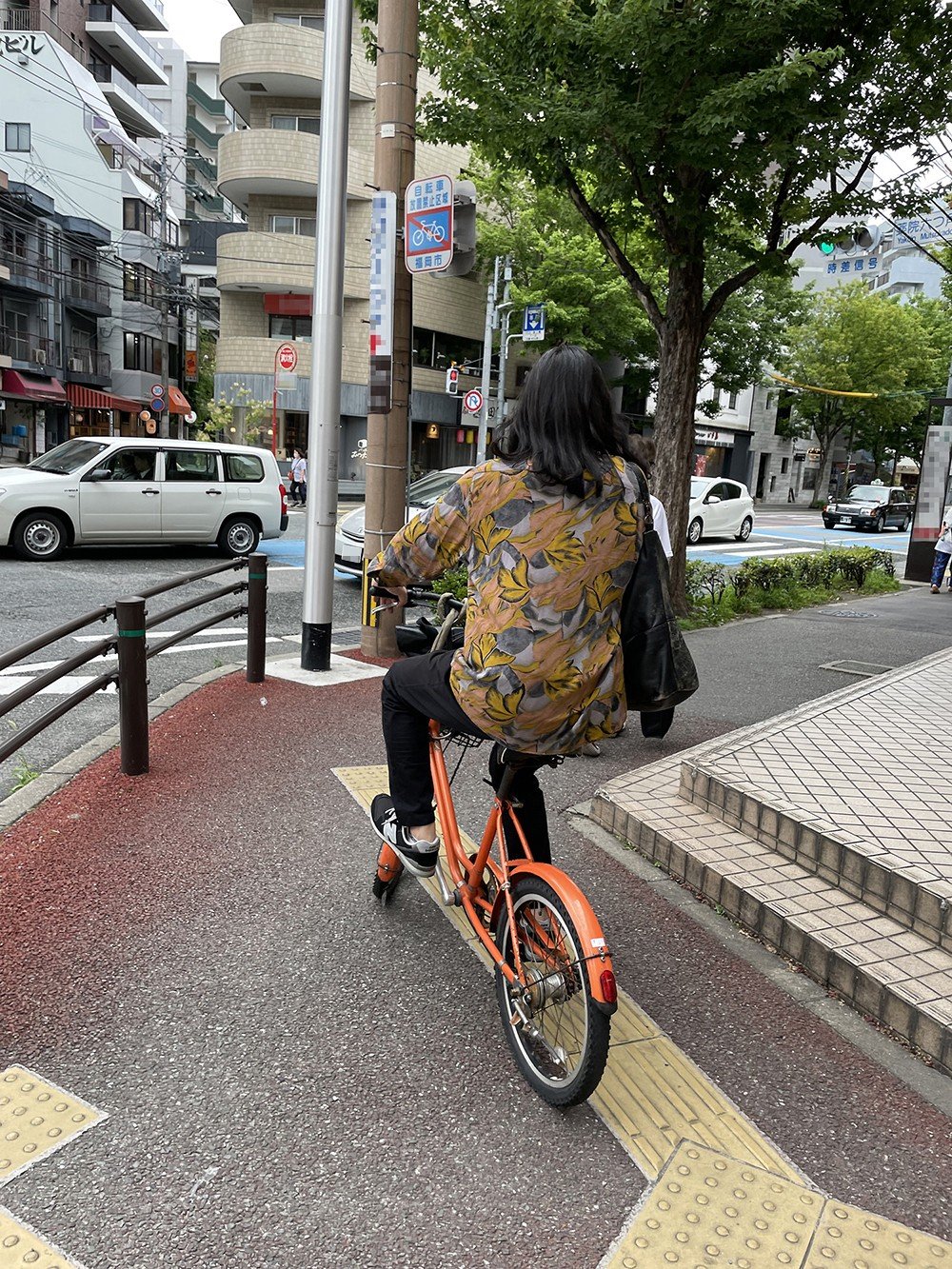 自転車で颯爽と街に消えていく今村の後ろ姿