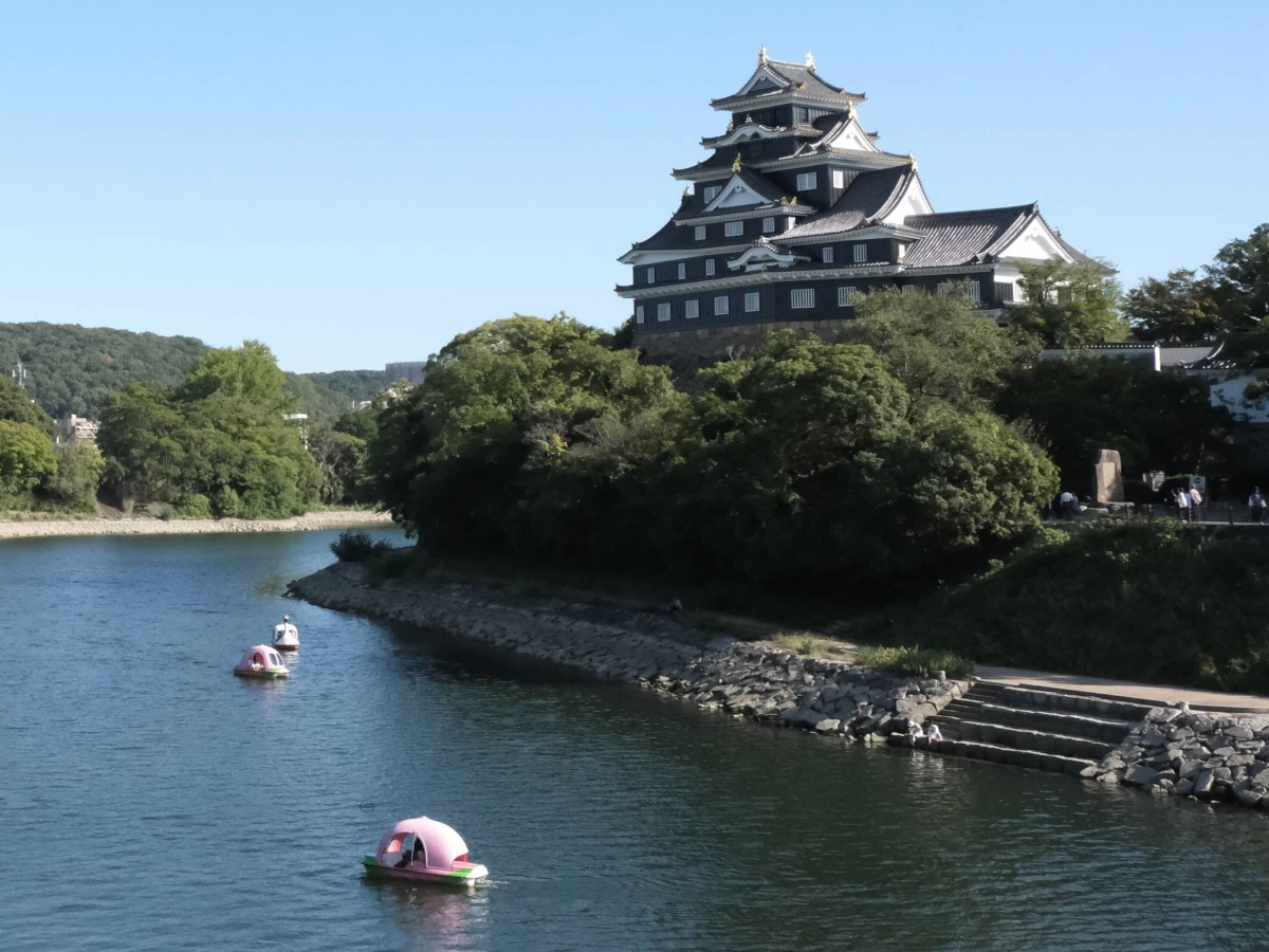 岡山城天守閣と、旭川に浮かぶ桃ボート