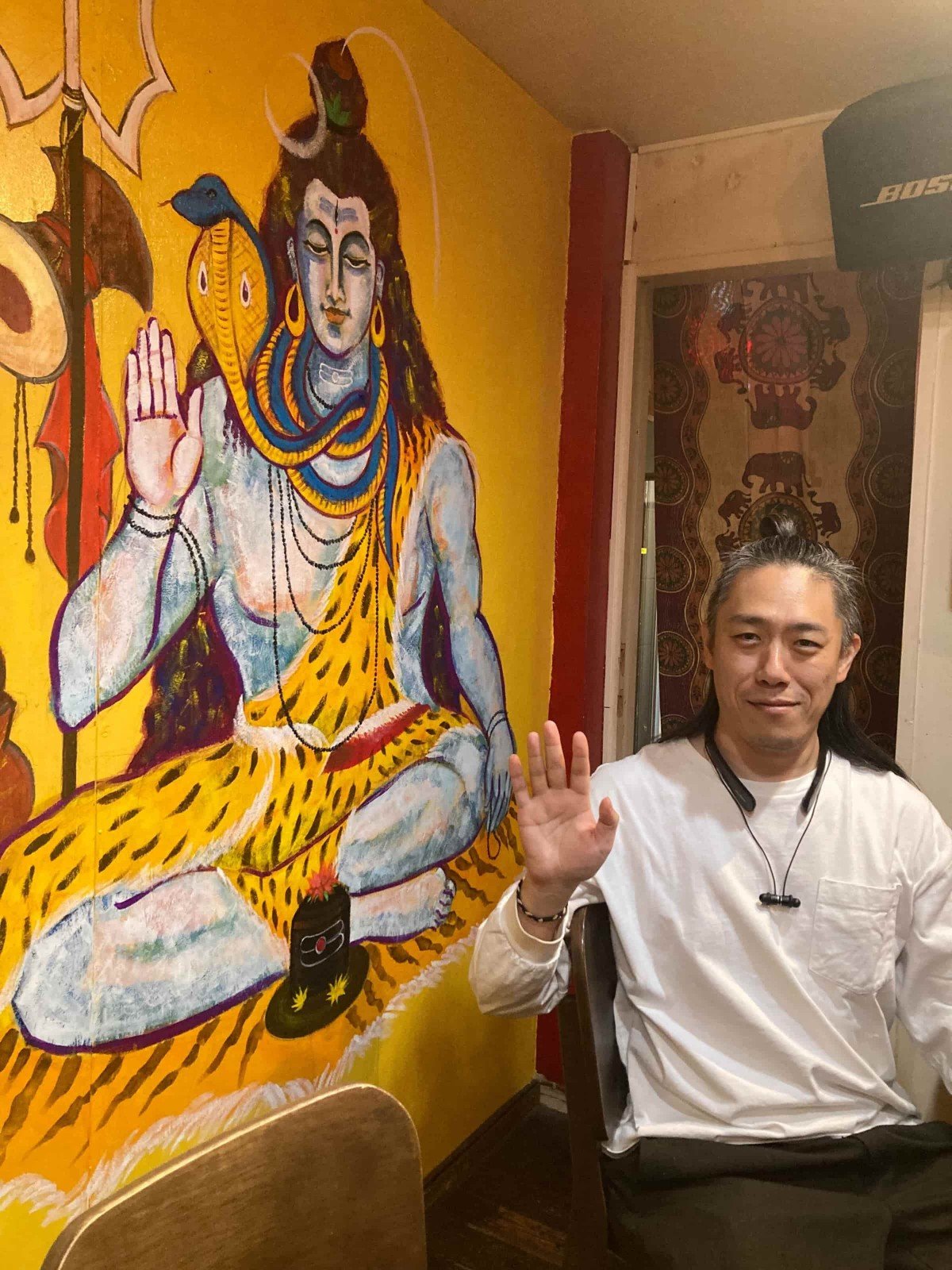 壁に描かれたシヴァ神と、同じポーズをとる今村さん