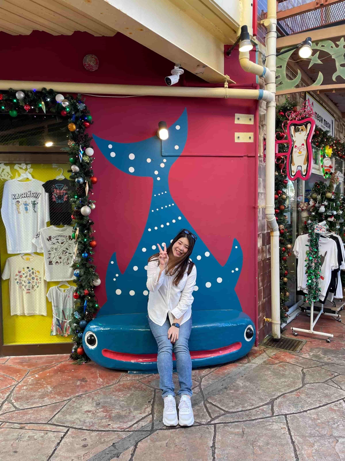 クリスマス仕様の街中でピースする福永さん