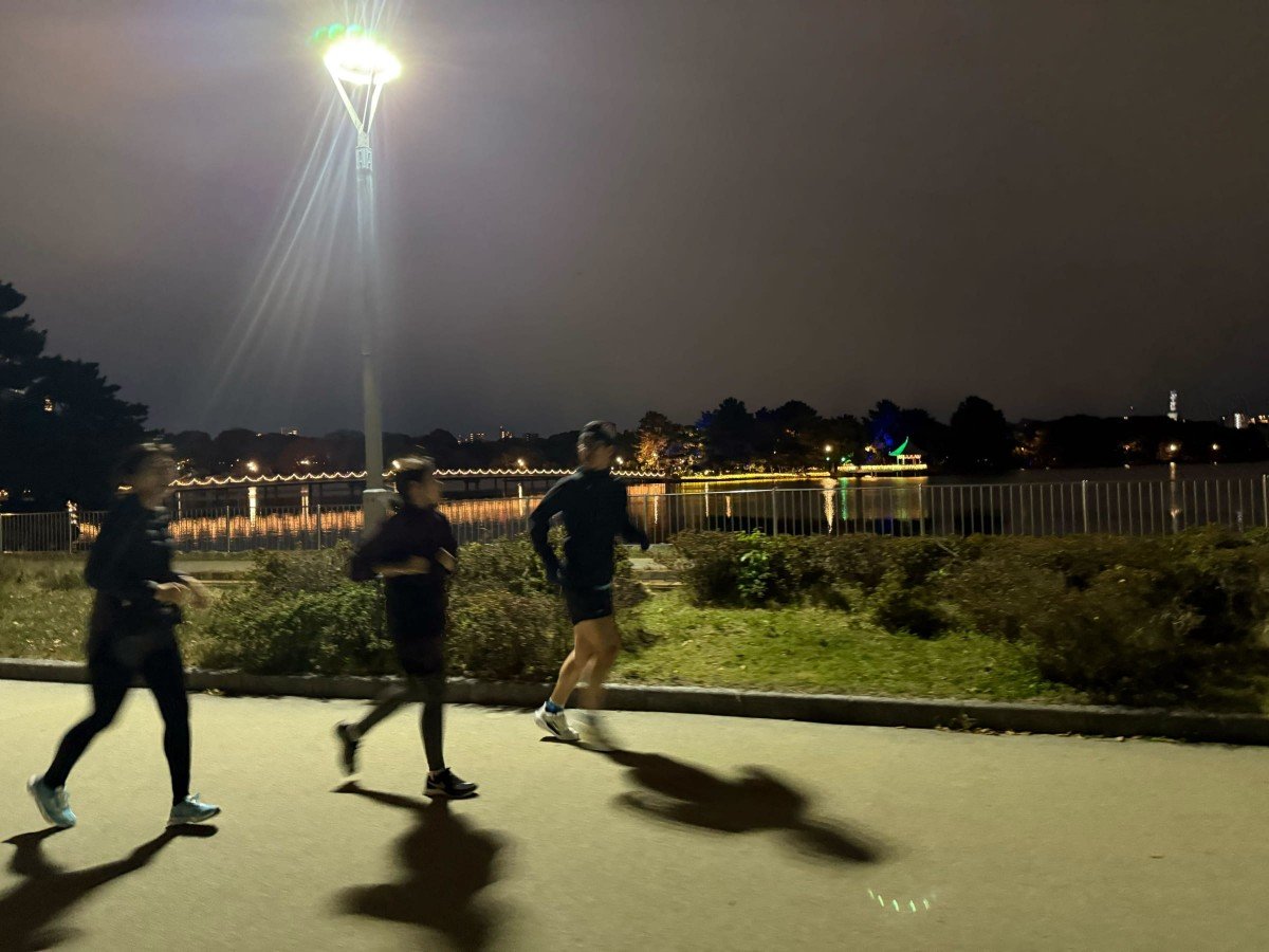 夜の大濠公園を駆け抜ける新津さん、米田さん、古田さん