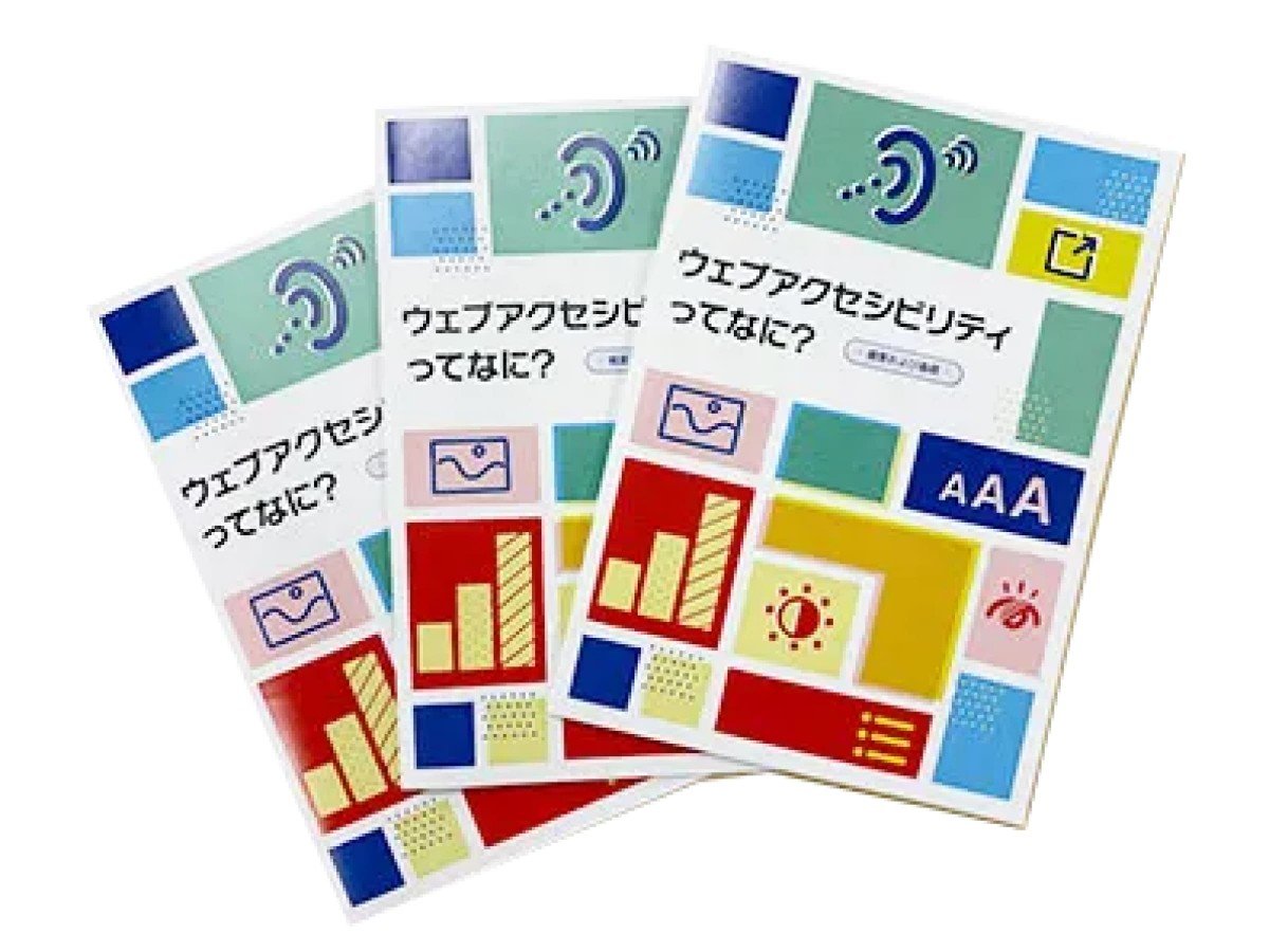 冊子「アクセシビリティってなに？」の完成版が3冊、扇のように重なっている画像。