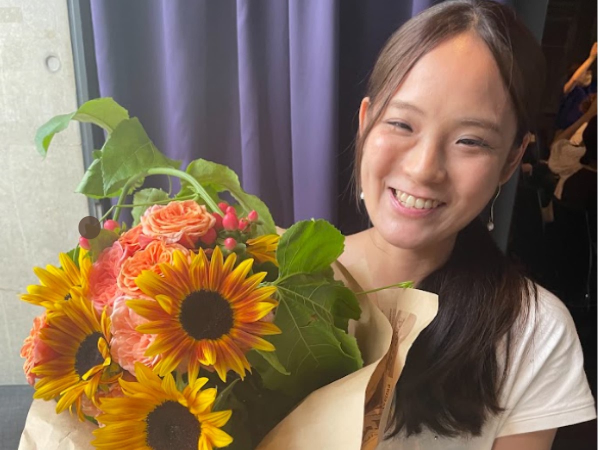 花束を手に微笑む山田さん