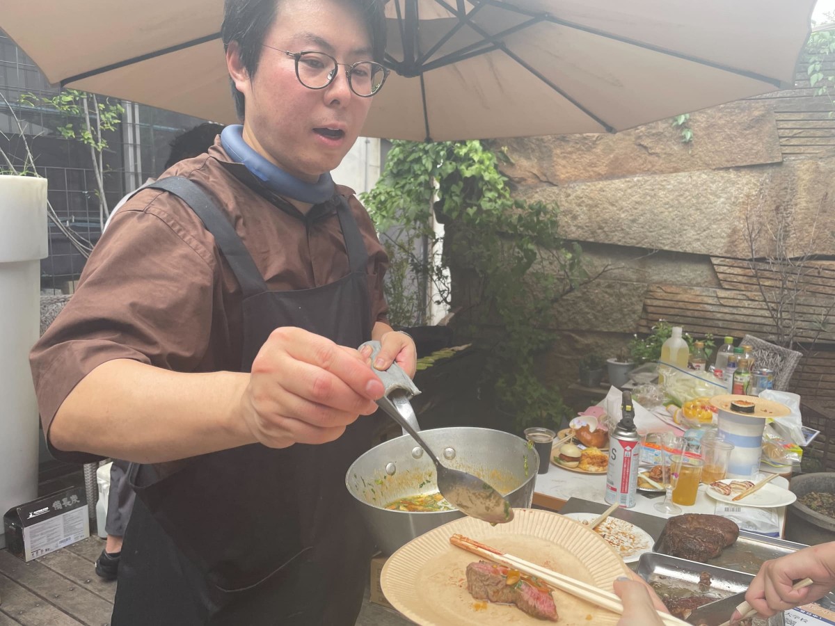肉にソースをかける渡邉亮さん