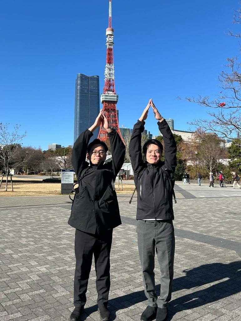 東京タワーの前で、谷口さんと小林さんが並んでタワーのポーズを取っている。