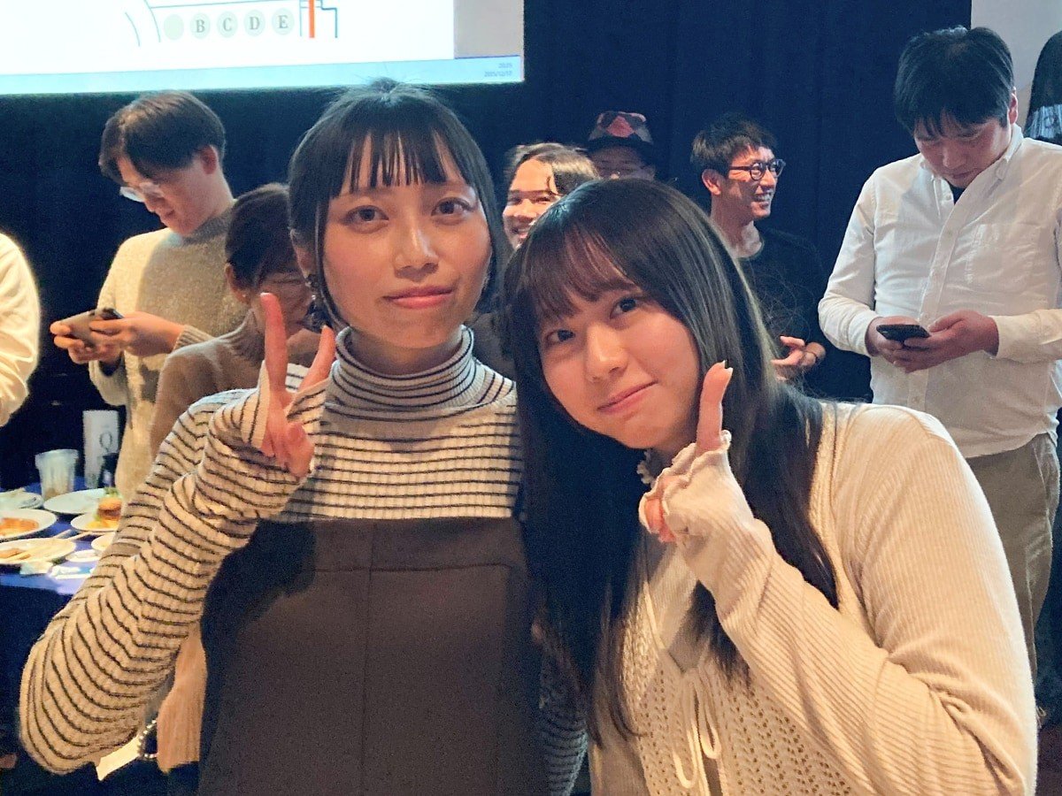 東京と福岡のメンバーの写真。二人寄り添って笑顔でピースサインをしている。