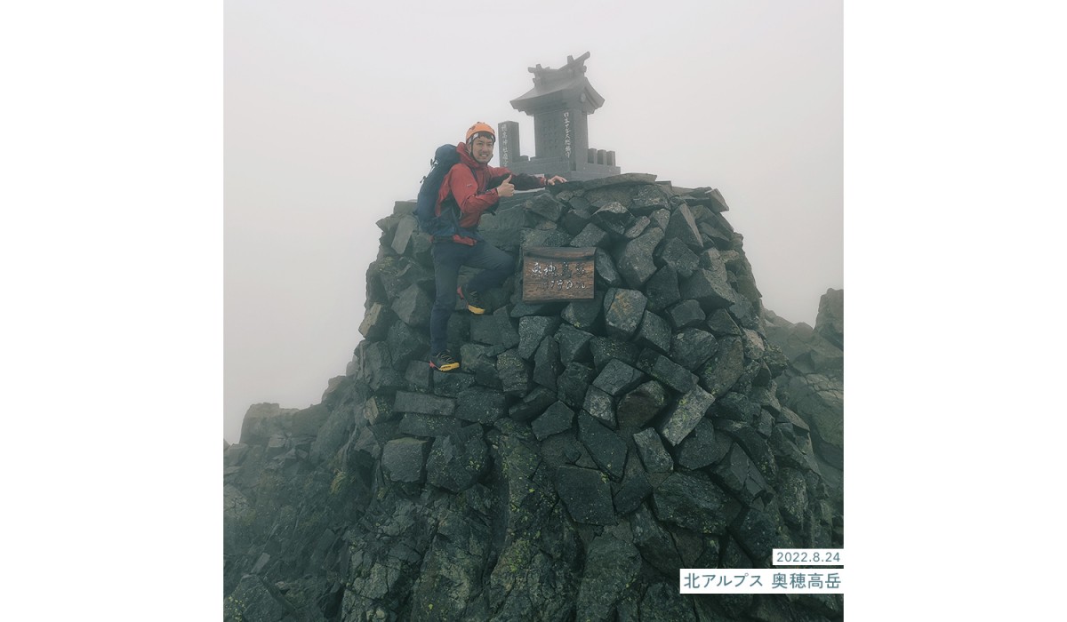 写真：2022.8.24 北アルプス 奥穂高岳山頂 筆者が登頂する様子。雲の中にいるため辺りが白く眺望がない